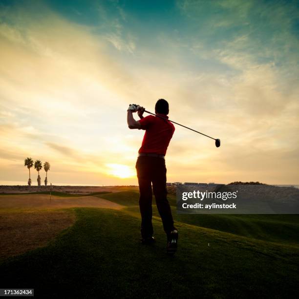 golfer swinging at sunset - golf swing sunset stock pictures, royalty-free photos & images