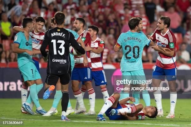 Players argue during the Spanish league football match between Granada FC and FC Barcelona at the Nuevo Estadio de Los Carmenes in Granada on October...