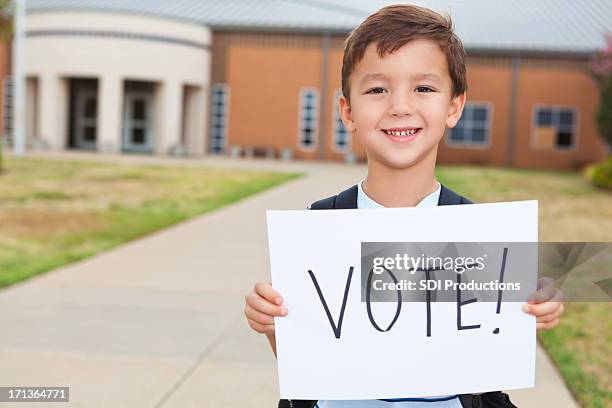 happy young student at school holding a vote sign - election day 個照片及圖片檔