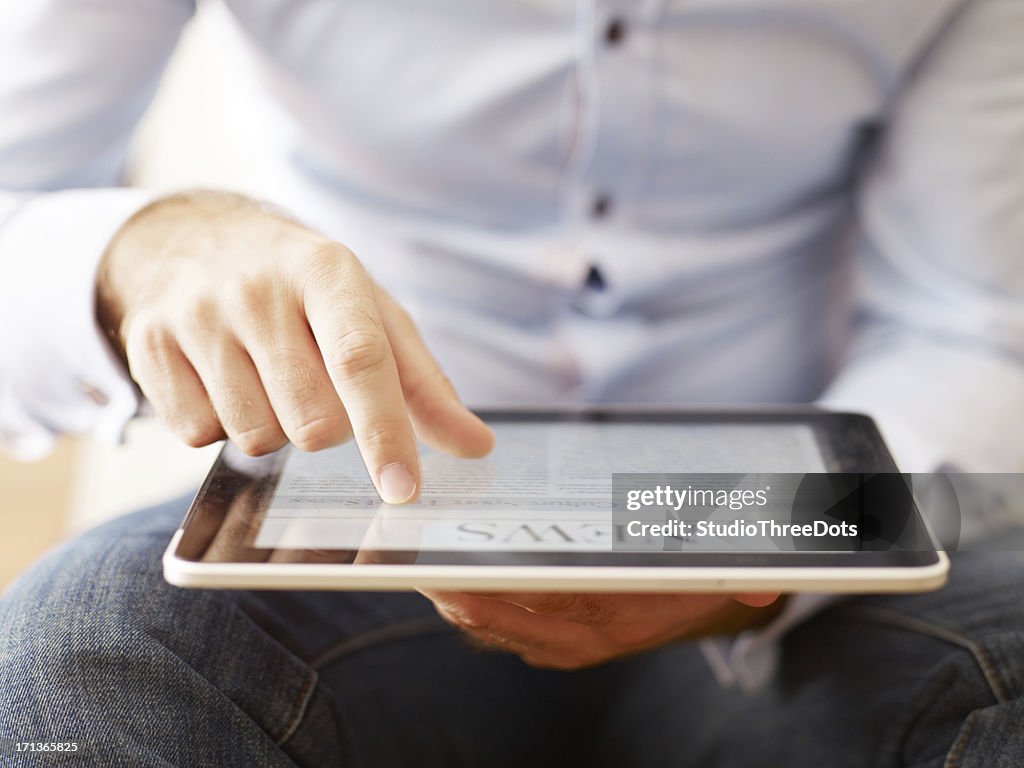 Man reading news on the digital tablet