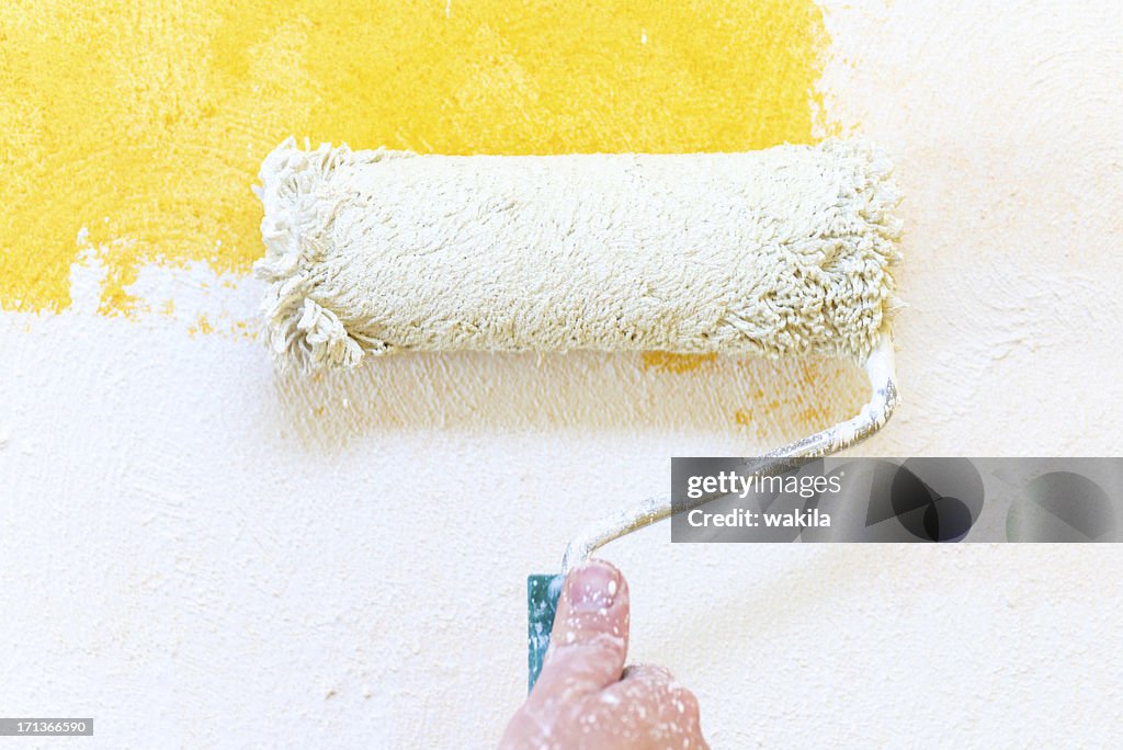 Painting hand with paintbrush yellow and white