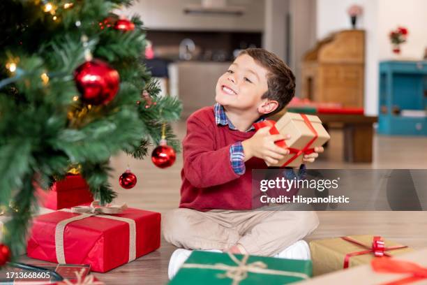 boy trying to guess his christmas present - shaking box stock pictures, royalty-free photos & images