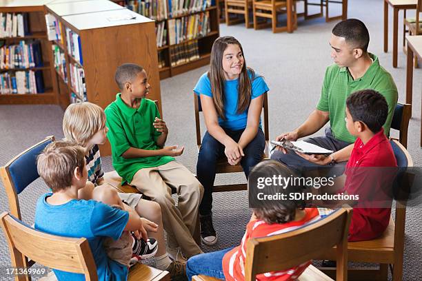 professor com os alunos em discussão com biblioteca - mentor - fotografias e filmes do acervo