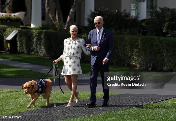 President Joe Biden walks with Selma Blair, Actress and Disability Rights Advocate, as they walk to an event honoring the Americans with Disabilities...
