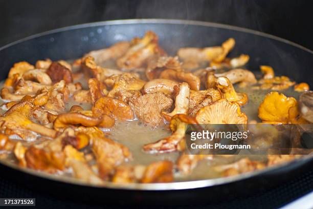 butter fried chanterelles on the frying pan - cantharellus tubaeformis stock pictures, royalty-free photos & images