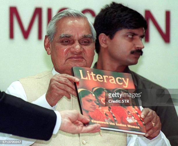 Indian Prime Minister Atal Behari Vajpayee display a copy of a special publication intitled "Literacy Empowers the Indian Woman " during a function...