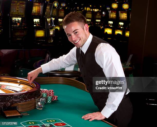 young roulette dealer in a casino - casino dealer stock pictures, royalty-free photos & images