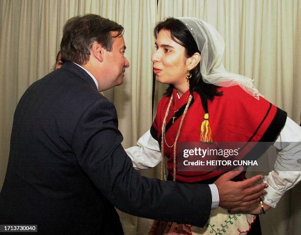Portugal's Prime Minister Antonio Guterres receives a kiss from a woman wearing a typical Portuguese costume 03 September 2001 during a visit to the...