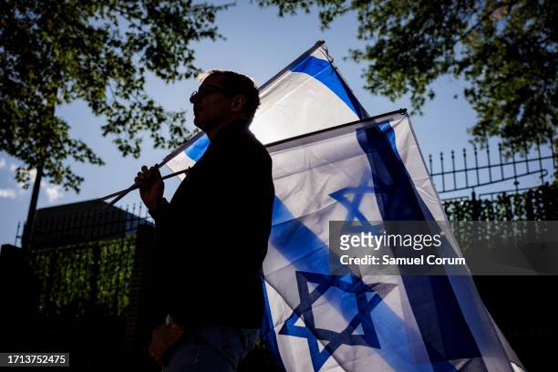 Man carries two Israeli flags during a pro-Israel rally outside of Israeli Embassy on October 8, 2023 in Washington, DC. The Palestinian militant...