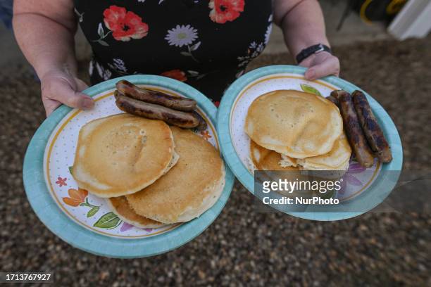 Woman holds two plates with a traditional pancake breakfast on the 3rd day of the Smoky Lake Great White North Pumpkin Fair 2023, on October 7 in...