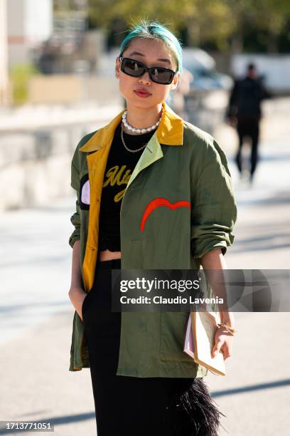 Margaret Zhang wears a black top, green printed jacket, black long skirt with fur details, outside Balenciaga, during the Womenswear Spring/Summer...