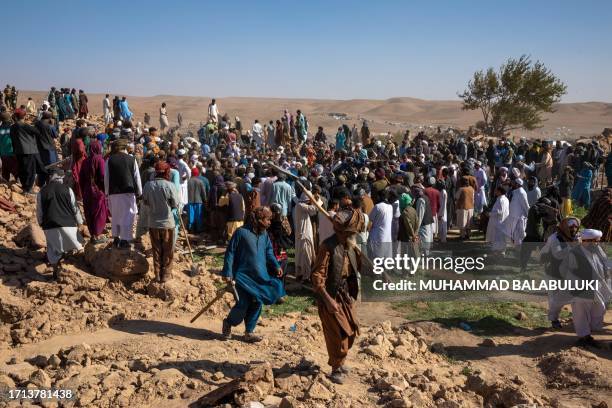 Herat, Afghanistan. Afghans gather on the remains of the ruined houses to excavate belongings and bodies after a massive 6.3 magnitude earthquake...