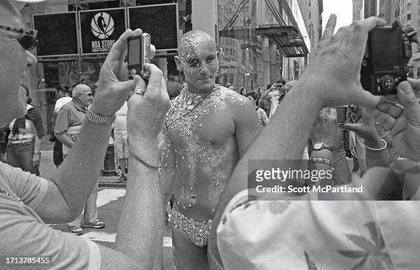 An unidentified parade participant, adorned with faux jewels, poses for photographers on 5th Avenue during the NYC Gay Pride March, New York, New...