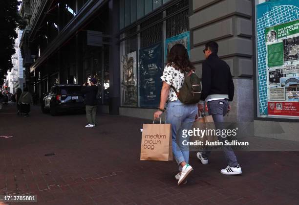 Pedestrian carries shopping bags while walking through the Union Square shopping district on October 02, 2023 in San Francisco, California. According...