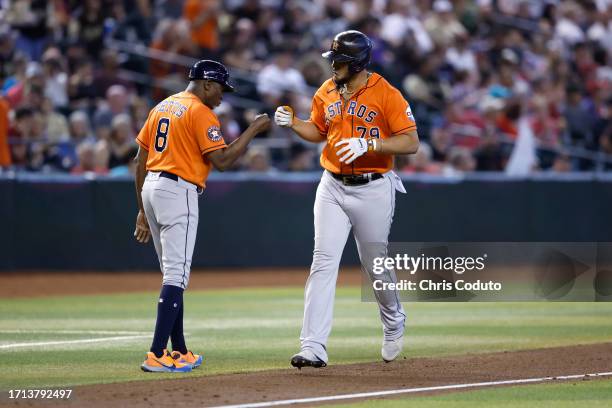 Jose Abreu of the Houston Astros bumps fists with third base coach Gary Pettis after hitting a two run home run during the seventh inning against the...