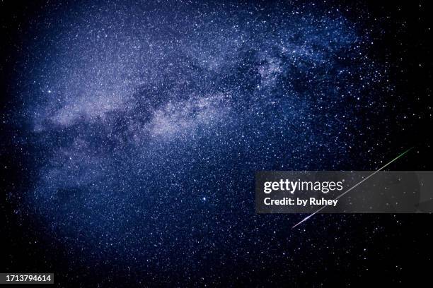 a meteor leaves a multicolored trail of light in the sky and crosses the milky way during the 2023 perseid meteor shower - astrologie photos et images de collection