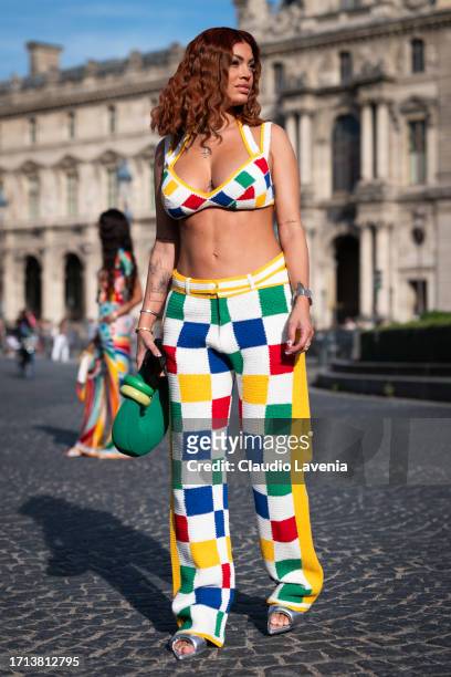 Melanie Da Cruz wears a colorful checked knitted crop top with matching pants and green bag, outside Casablanca, during the Womenswear Spring/Summer...