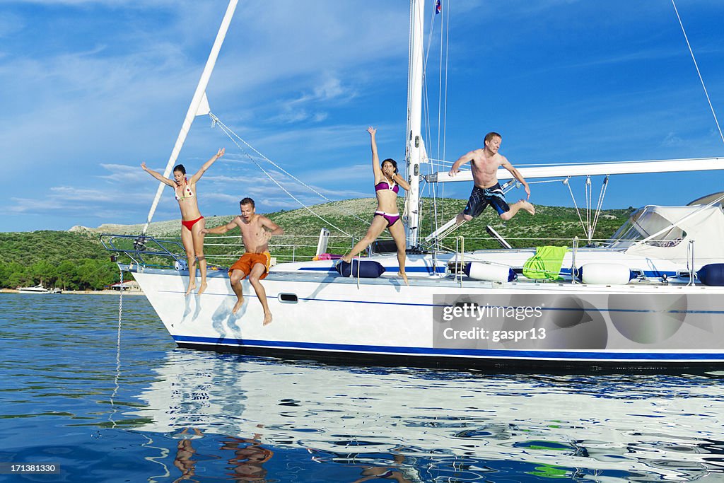 Fröhlich Freunde springen auf einer yacht