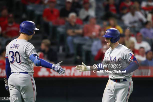 Mitch Garver of the Texas Rangers celebrates his home run with Nathaniel Lowe in the sixth inning against the Los Angeles Angels at Angel Stadium of...