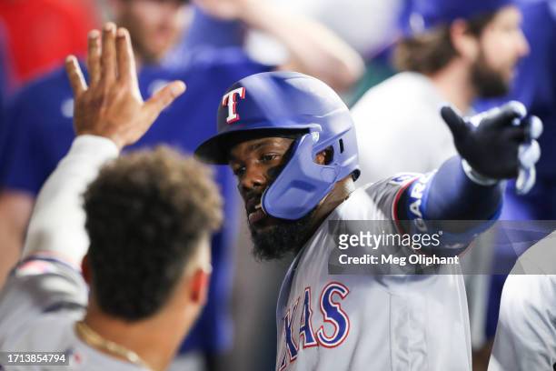 Adolis Garcia of the Texas Rangers celebrates in the dugout after scoring a home run in the sixth inning against the Los Angeles Angels at Angel...