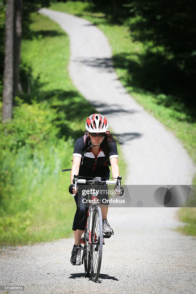 Young Woman Cycling in Forest in Summer