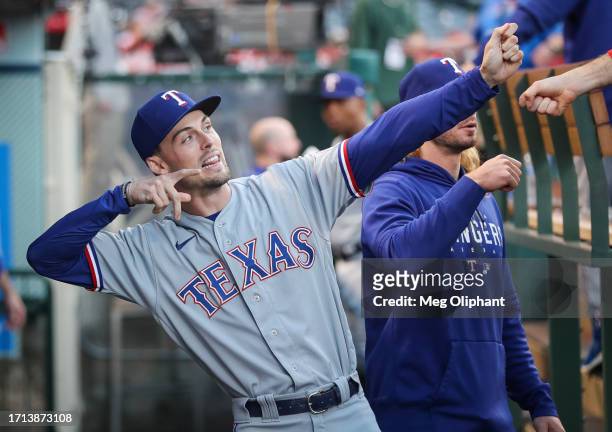 Evan Carter of the Texas Rangers interacts with teammates before the game against the Los Angeles Angels at Angel Stadium of Anaheim on September 25,...
