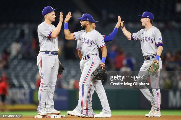 Corey Seager, Leody Taveras and Evan Carter of the Texas Rangers celebrate after defeating the Los Angeles Angels at Angel Stadium of Anaheim on...