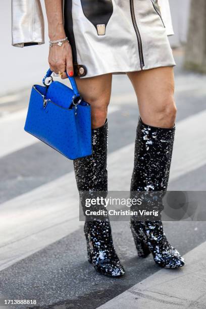 Guest wears blue bag, glitter boots outside Louis Vuitton during the Womenswear Spring/Summer 2024 as part of Paris Fashion Week on October 02, 2023...