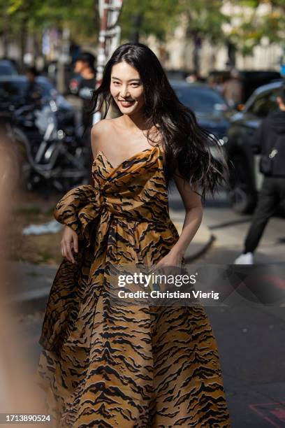 Guest wears animal tiger print dress outside Zimmermann during the Womenswear Spring/Summer 2024 as part of Paris Fashion Week on October 02, 2023 in...