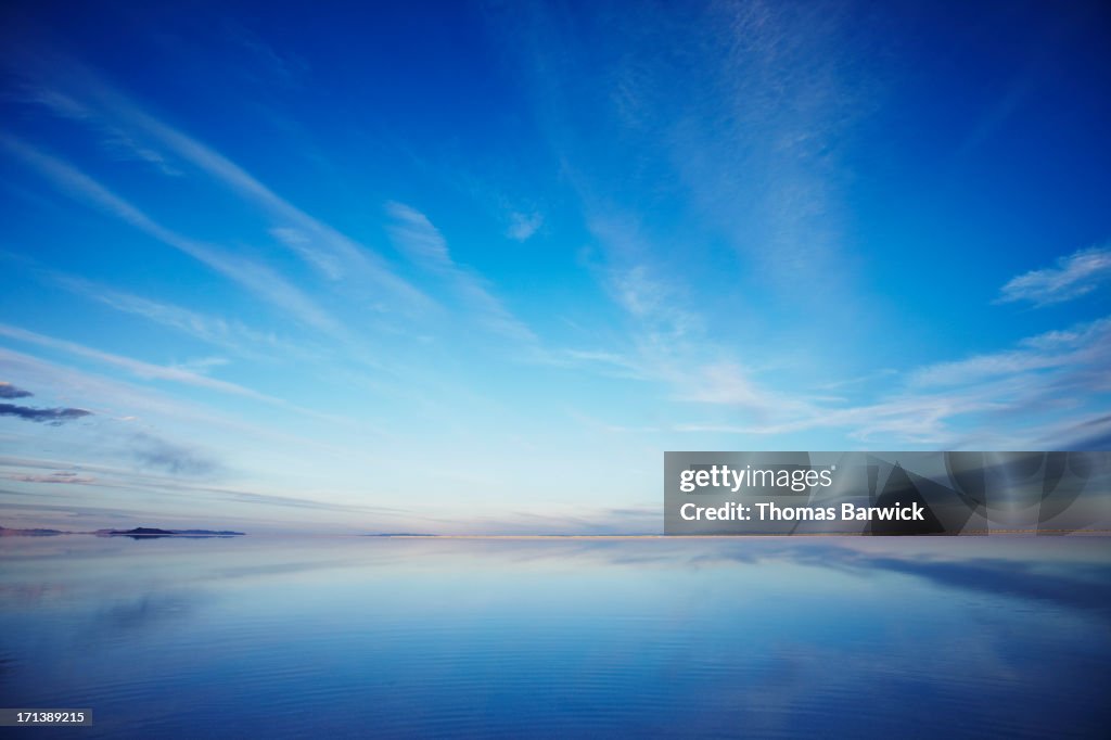 Sky reflecting in calm lake at sunset