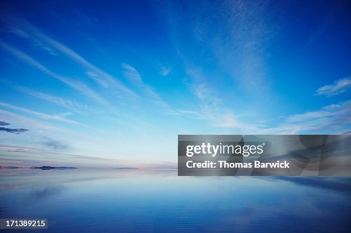 Sky reflecting in calm lake at sunset Sky reflecting in calm lake at sunset