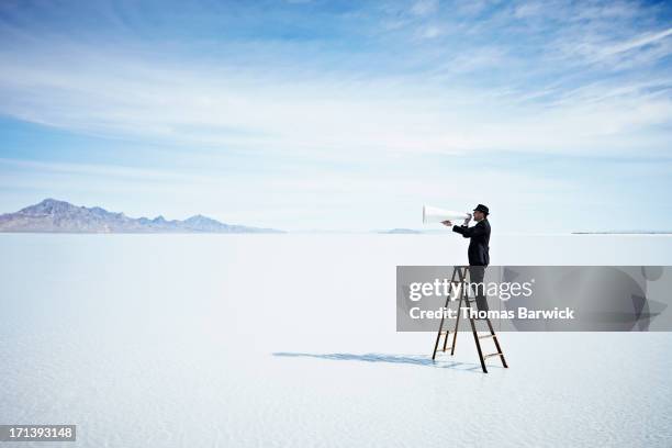 businessman with megaphone on ladder in lake - assertiveness 個照片及圖片檔