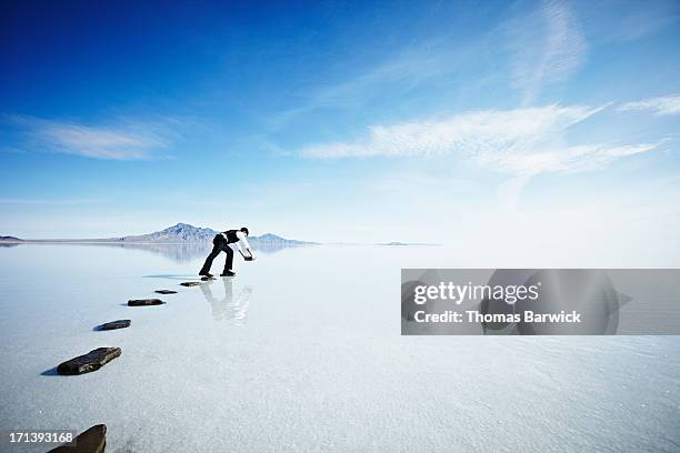 businessman placing next stone in pathway in lake - fast forward bildbanksfoton och bilder