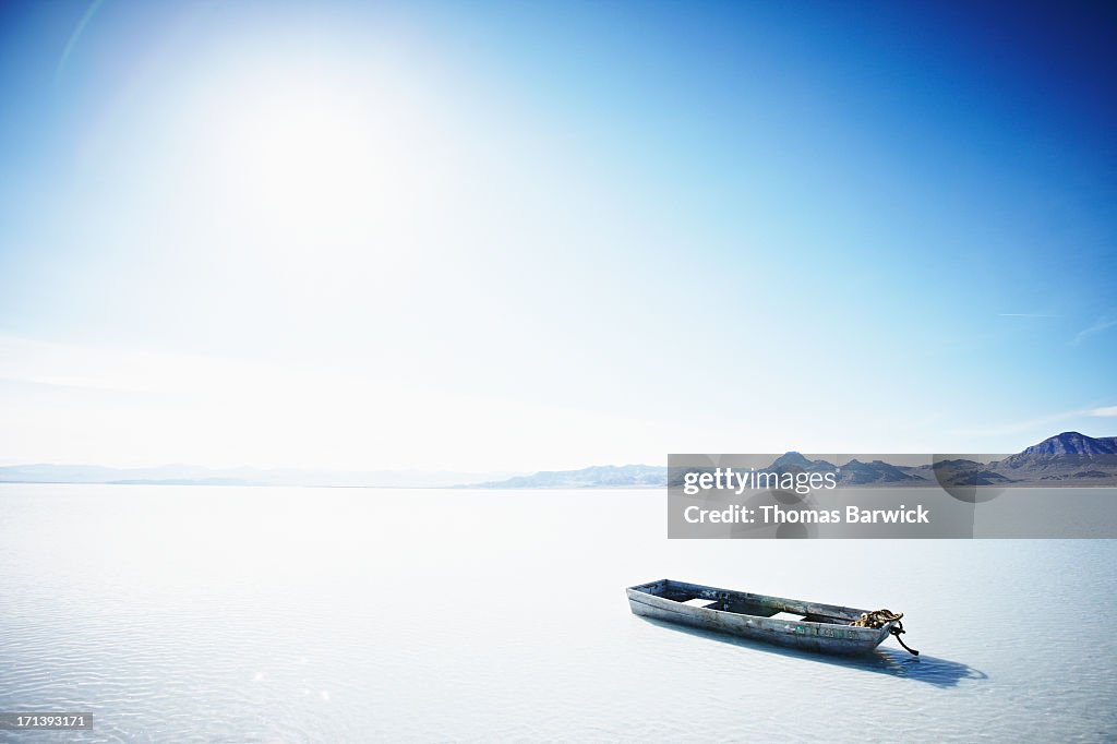 Small boat floating in water under intense sun