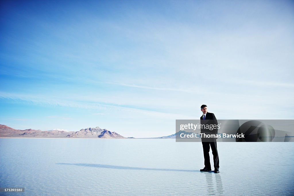 Businessman standing on surface of lake