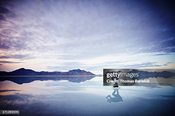 speed skater skating on calm lake at sunset - the bigger picture fotografías e imágenes de stock