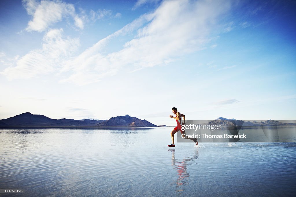 Athlete sprinting across surface of lake