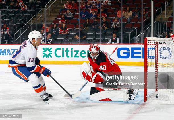 Mathew Barzal of New York Islanders scores a first period goal against Akira Schmid of New Jersey Devils during a preseason game at the Prudential...