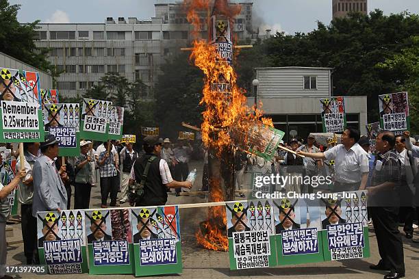 South Korean conservative protesters burn a mock of North Korea's missile and anti-North Korea placards during an anti-North Korea rally to mark 63rd...