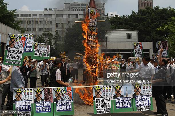 South Korean conservative protesters burn a mock of North Korea's missile and anti-North Korea placards during an anti-North Korea rally to mark 63rd...