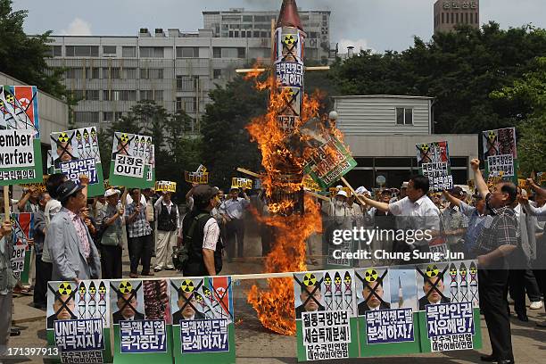 South Korean conservative protesters burn a mock of North Korea's missile and anti-North Korea placards during an anti-North Korea rally to mark 63rd...