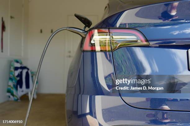 Model Y car sits inside a home garage whilst receiving a top up charge of solar powered electricity on October 03, 2023 in Ballina, Australia.