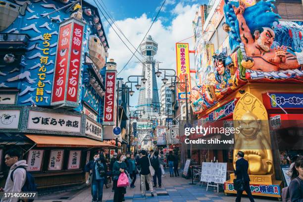 der tsutenkaku-turm in osaka in japan mit seinen lebendigen und farbenfrohen schildern hat nach der covid-19-pandemie ein wiederaufleben der touristenmassen erlebt. - osaka skyline stock-fotos und bilder