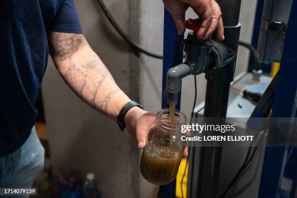 Ryan Pulley, director of water re-use operations for startup Epic Cleantec, takes a sample of untreated water in the basement of a downtown building...