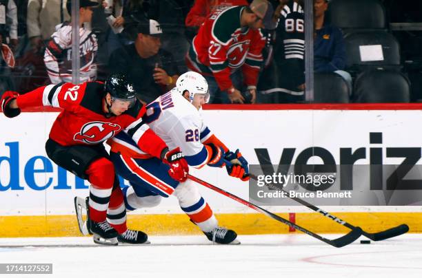 Alexander Romanov of New York Islanders carries the puck against Curtis Lazar of New Jersey Devils during the third period during a preseason game at...