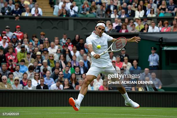 Switzerland's Roger Federer returns against Romania's Victor Hanescu during their men's first round match on day one of the 2013 Wimbledon...