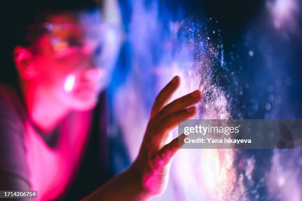 a person touching the digital interface. interaction with the unknown and cosmic exploration - interactief stockfoto's en -beelden