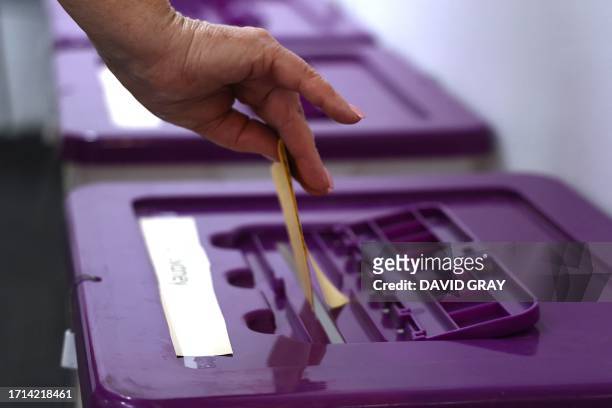 In this photo taken on October 3 a voter puts their vote into a ballot box at a voting centre in central Sydney. Next weekend's referendum will...
