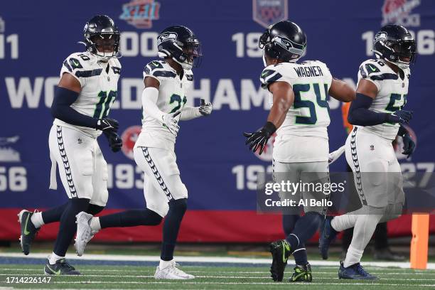 Devon Witherspoon of the Seattle Seahawks celebrates his interception return for a touchdown with teammates during the third quarter against the New...