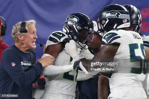 Devon Witherspoon of the Seattle Seahawks celebrates his interception return for a touchdown with Head coach Pete Carroll and teammates during the...